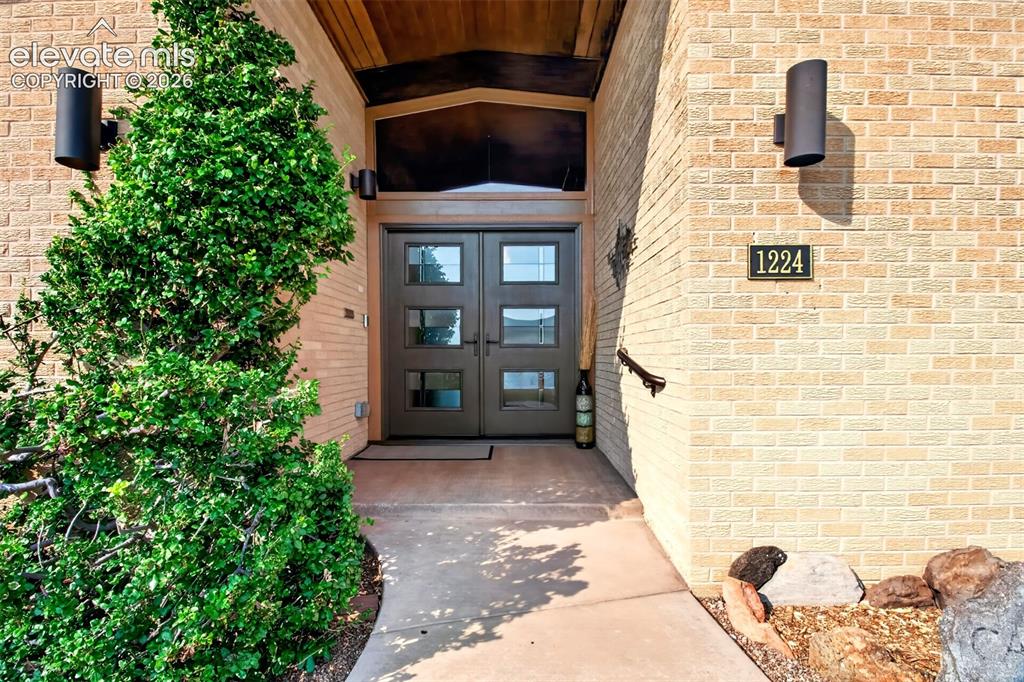 Image 5 of 49: The covered front entry has updated double front doors.