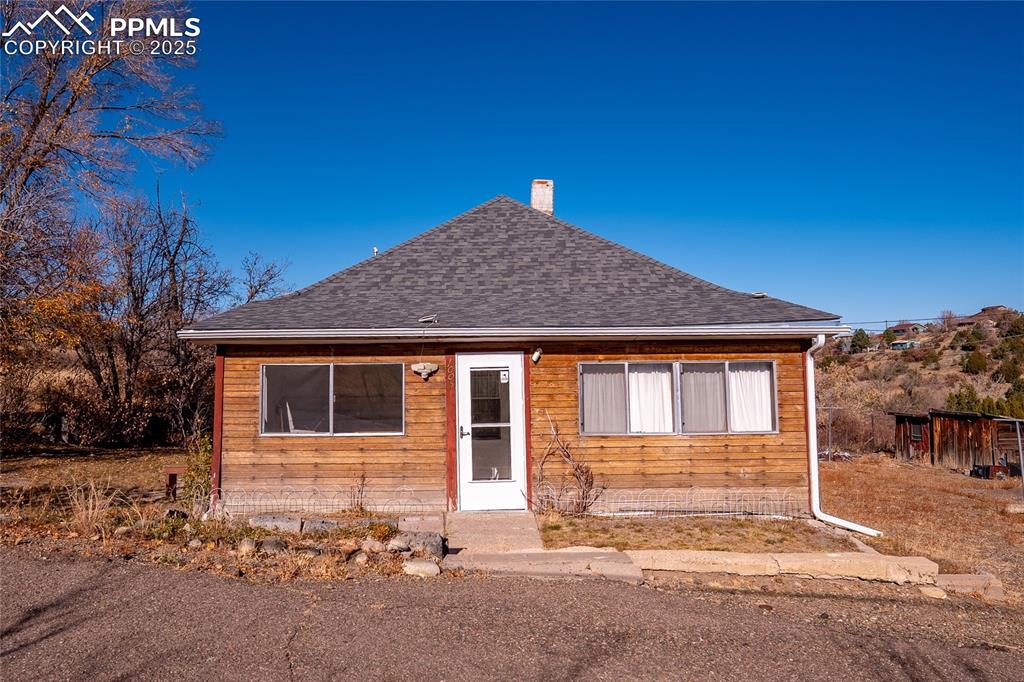 Image 1 of 21: View of front of home featuring a chimney and a shingled roof