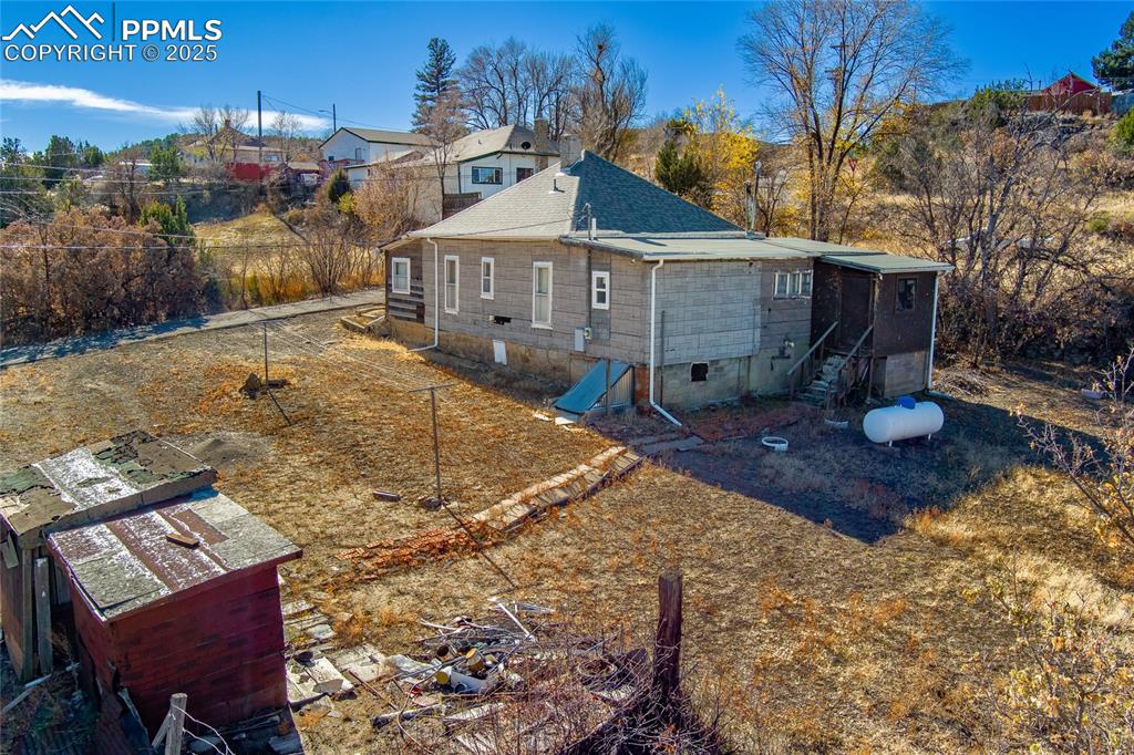 Image 18 of 23: Rear view of house with crawl space and roof with shingles