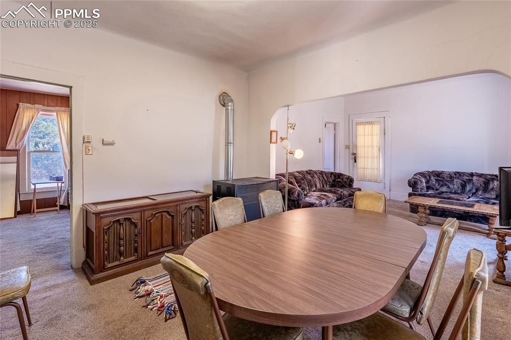 Image 5 of 21: Dining area with carpet flooring and arched walkways