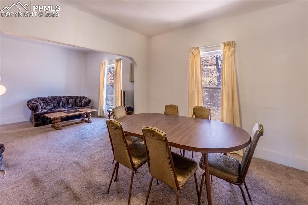 Image 6 of 21: Carpeted dining room with arched walkways and baseboards