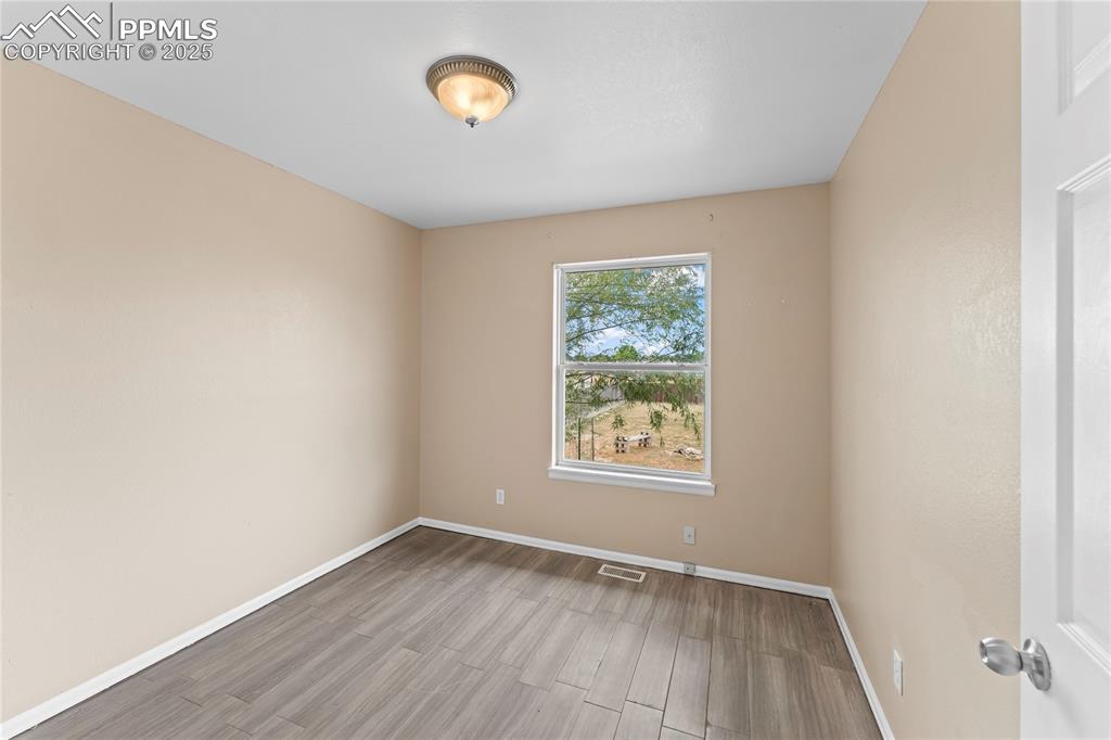 Image 11 of 29: Empty room with wood finished floors and baseboards