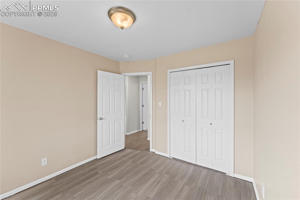 Image 12 of 29: Unfurnished bedroom with wood finished floors and a closet