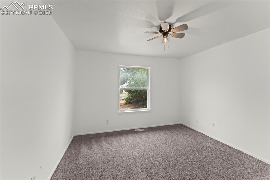 Image 13 of 29: Carpeted spare room with ceiling fan and baseboards