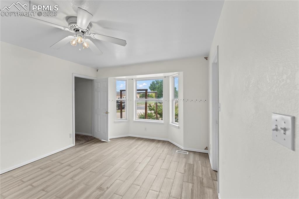 Image 15 of 29: Empty room featuring light wood-style floors and a ceiling fan