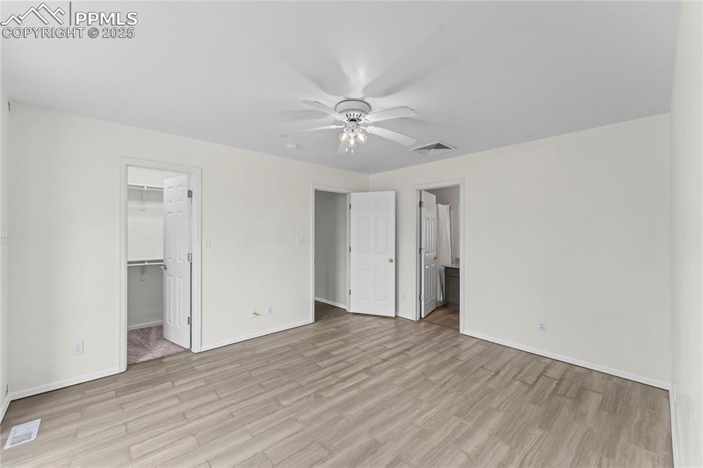 Image 16 of 29: Unfurnished bedroom featuring light wood-style flooring, a walk in closet, 