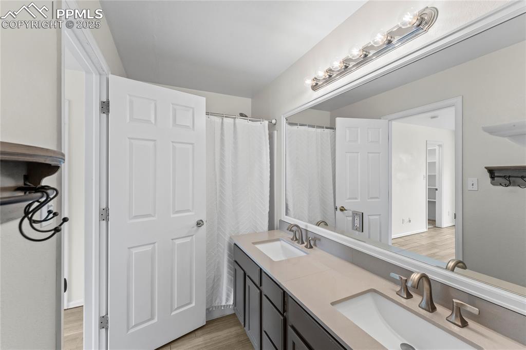 Image 17 of 29: Full bathroom featuring double vanity and wood finished floors
