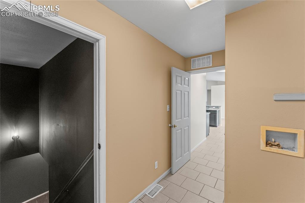 Image 18 of 29: Corridor featuring light tile patterned flooring and baseboards