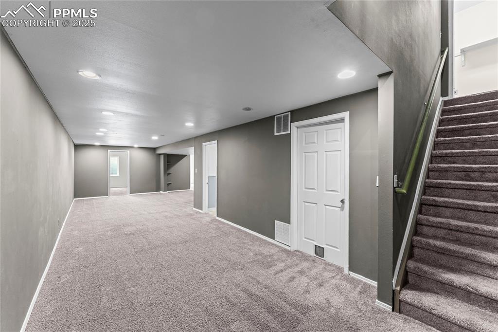 Image 19 of 29: Basement with carpet, recessed lighting, and stairs