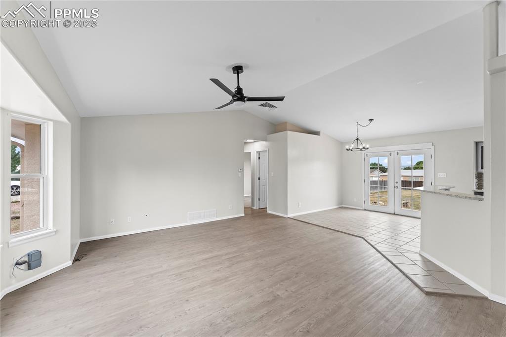 Image 3 of 29: Unfurnished living room featuring vaulted ceiling, light wood-type flooring
