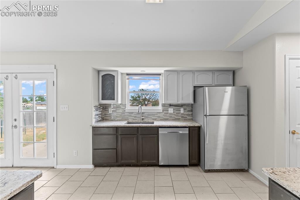 Image 7 of 29: Kitchen with tasteful backsplash, appliances with stainless steel finishes,