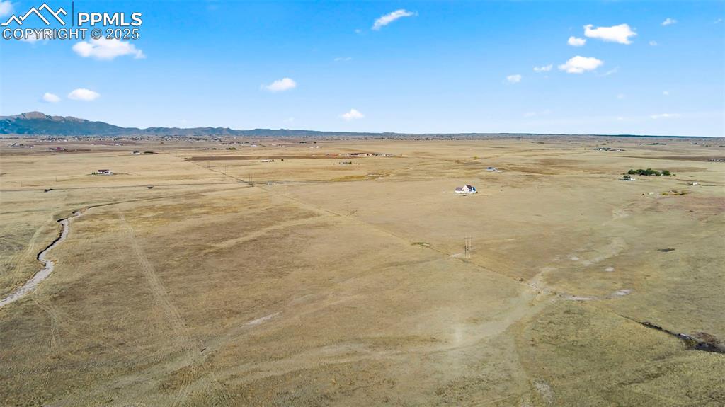 Image 7 of 10: View of rural area featuring a desert landscape and a mountainous backgroun