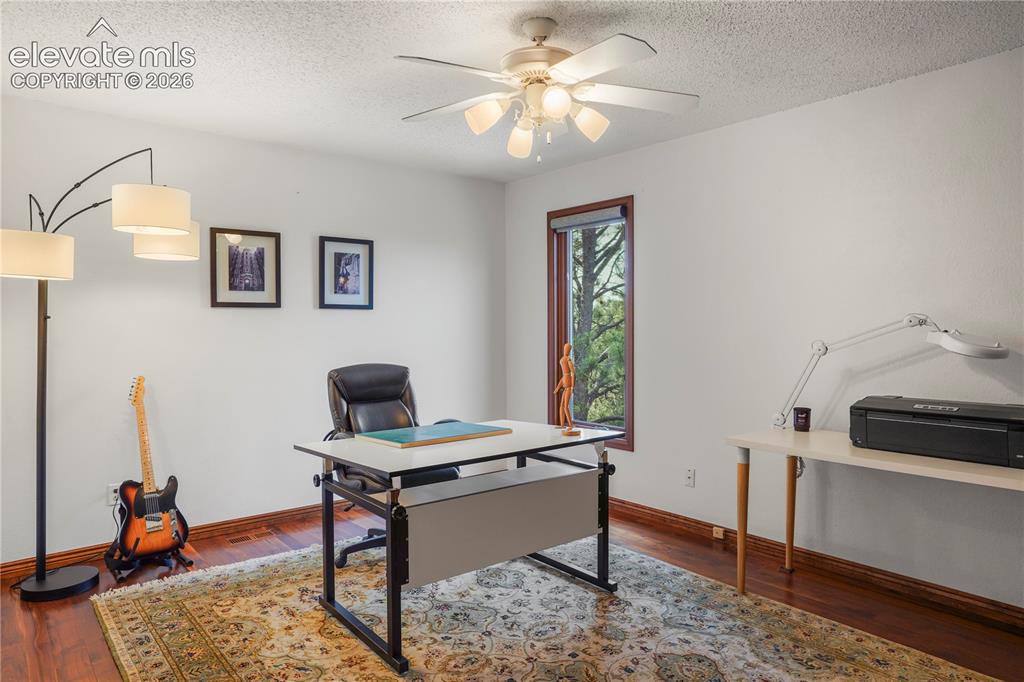 Image 26 of 39: Upstairs guest bedroom #3 with black walnut flooring and mountain views...a