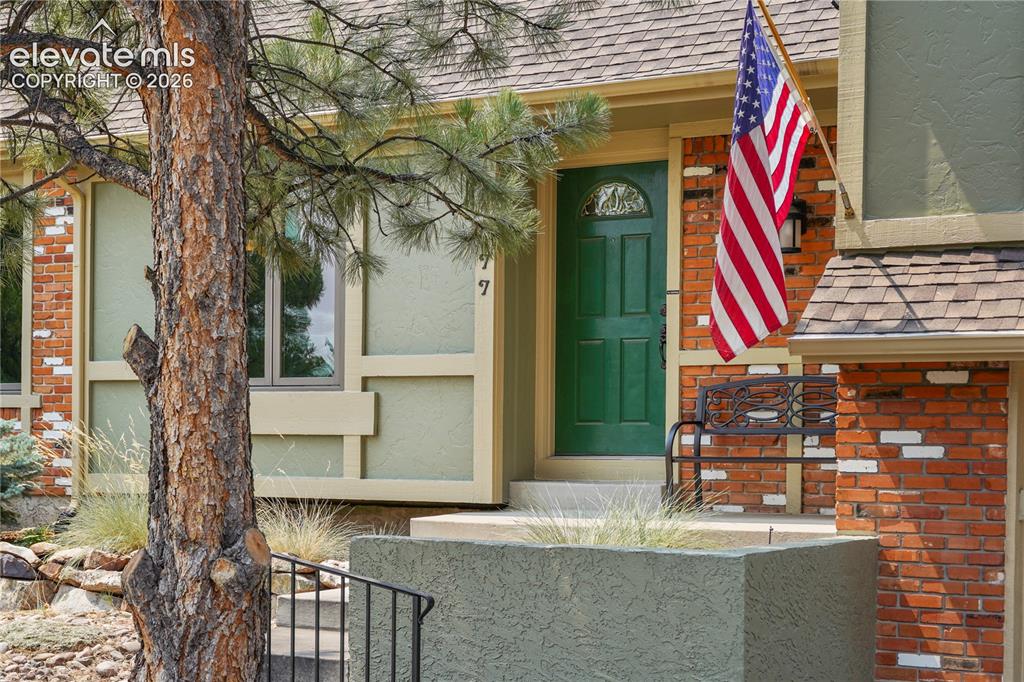 Image 3 of 39: mature landscaping and semi-covered front entry.