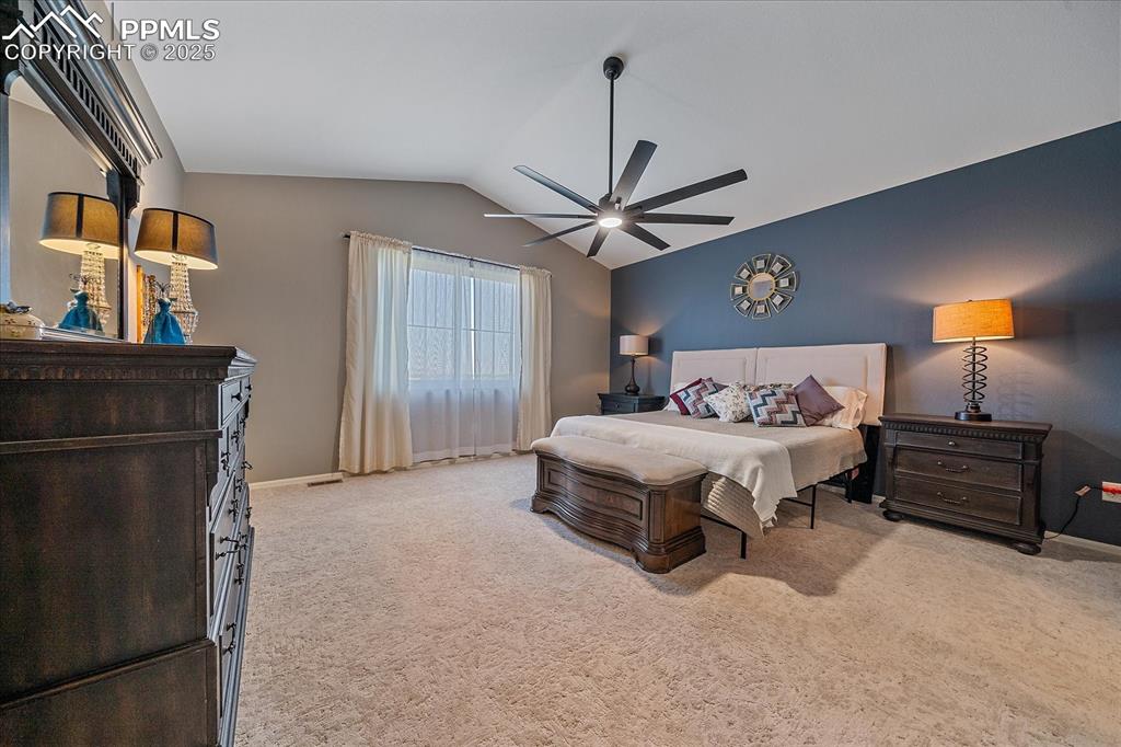 Image 17 of 49: Bedroom with lofted ceiling, light colored carpet, and a ceiling fan