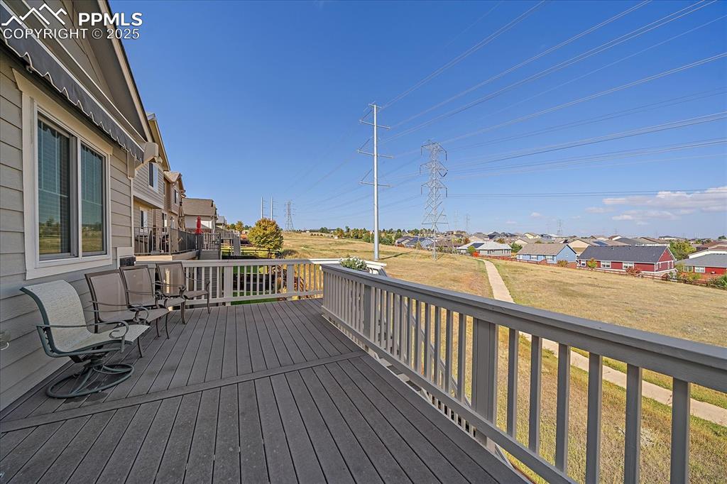 Image 27 of 49: Wooden terrace with a residential view and a lawn