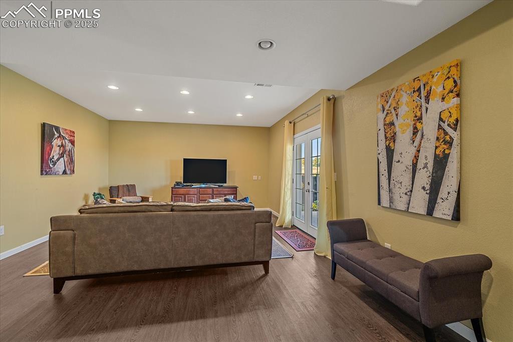 Image 30 of 49: Living/Bonus area in basement with french doors, recessed lighting, and woo