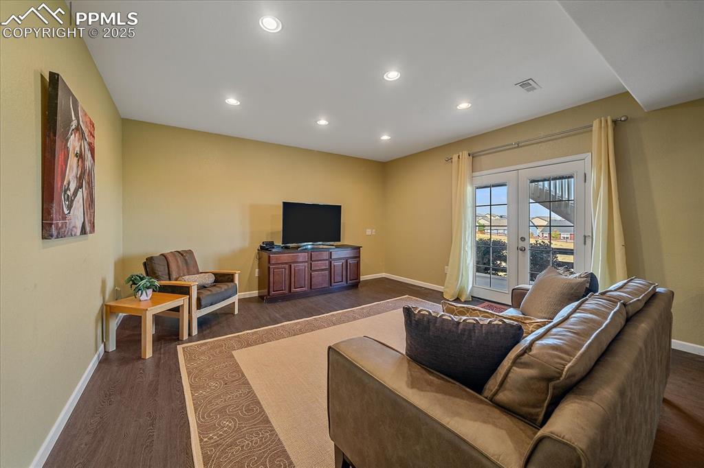 Image 32 of 49: Living area featuring french doors, recessed lighting, and dark wood-style 