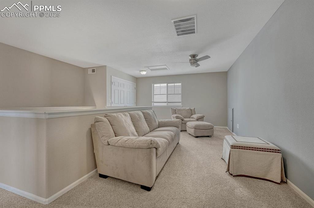 Image 25 of 35: Living area featuring attic access, light colored carpet, visible vents, an