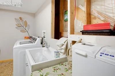 Image 24 of 30: Washroom with washer and dryer, baseboards, a sink, and laundry area