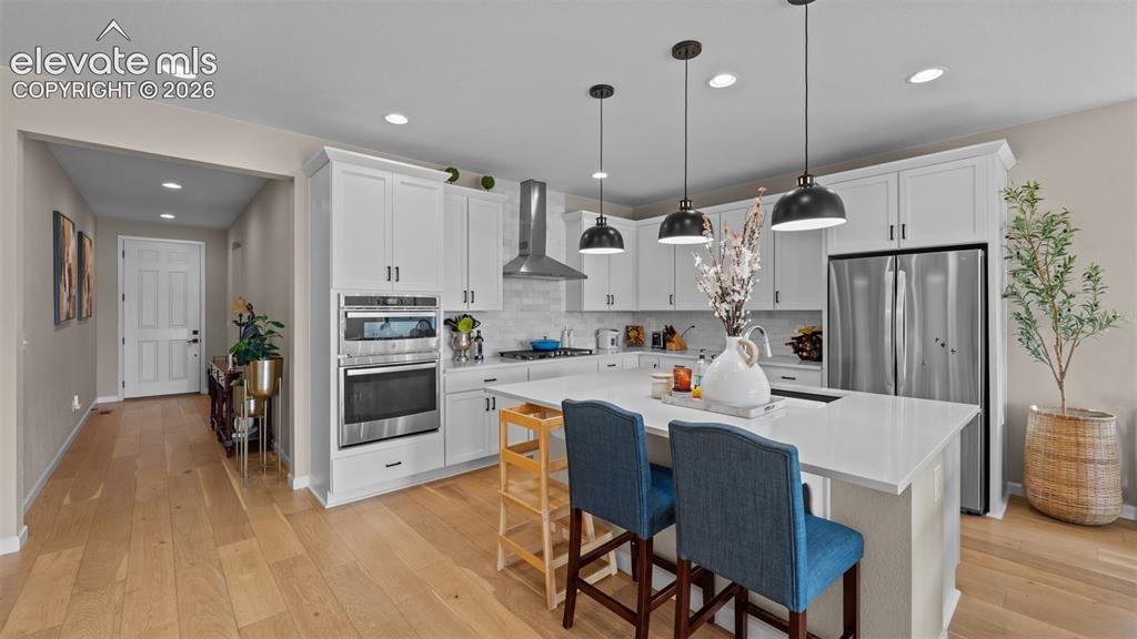 Image 10 of 46: Spacious kitchen featuring an island with seating, stainless steel applianc
