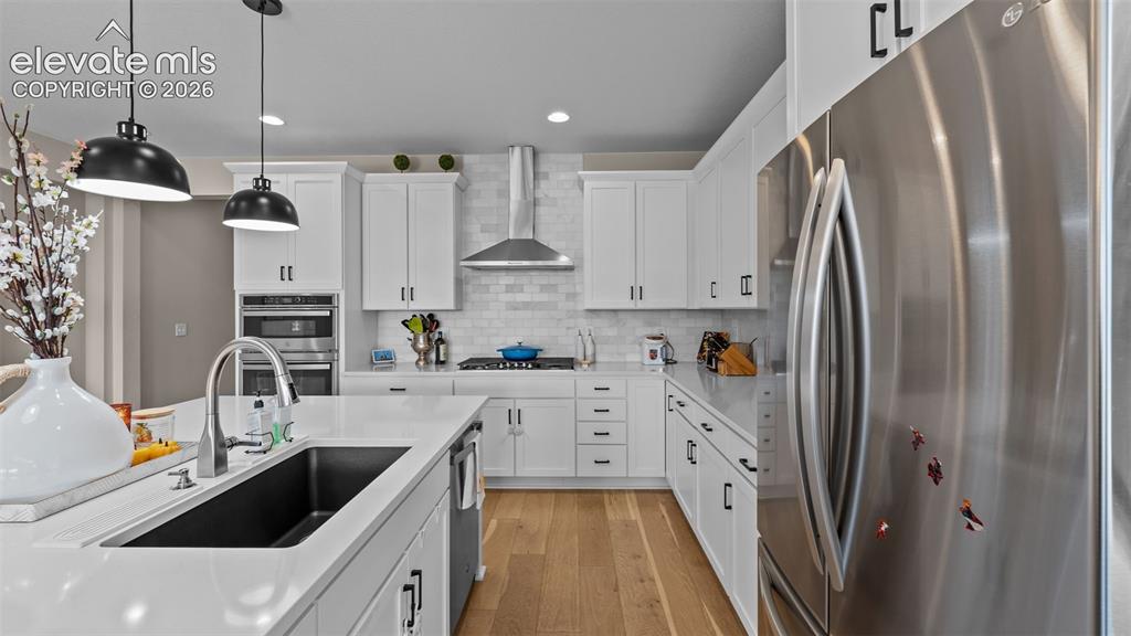 Image 14 of 46: Kitchen featuring white cabinetry, stainless steel appliances, a white tile
