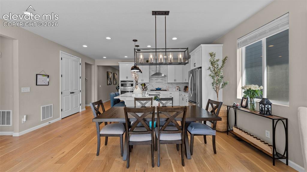 Image 17 of 46: Open-concept design with wood-finish flooring, recessed lighting, and a mod