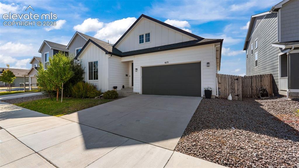 Image 2 of 46: White horizontal siding exterior with black trim accents and a dark garage
