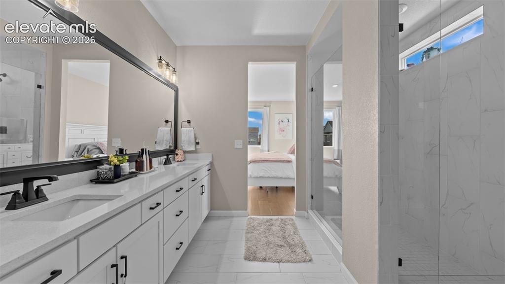 Image 23 of 46: Dual vanity with undermount sinks, white cabinetry, and matte black hardwar