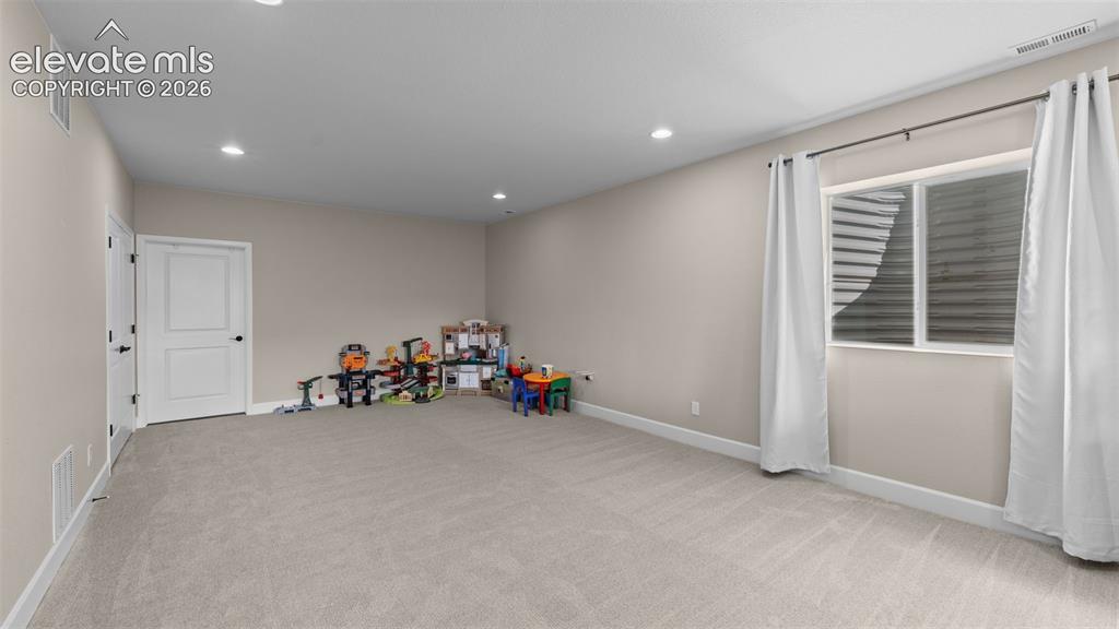 Image 28 of 46: Carpeted room with recessed lighting, light-toned walls, and a window with 