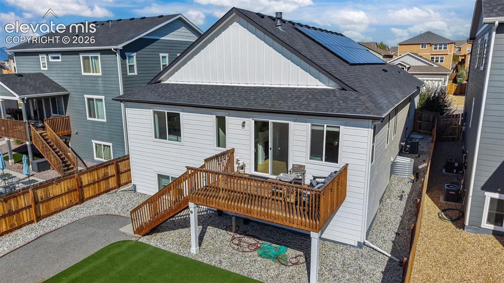 Image 36 of 46: Raised wood deck, solar panels, gravel landscaping, horizontal siding, and