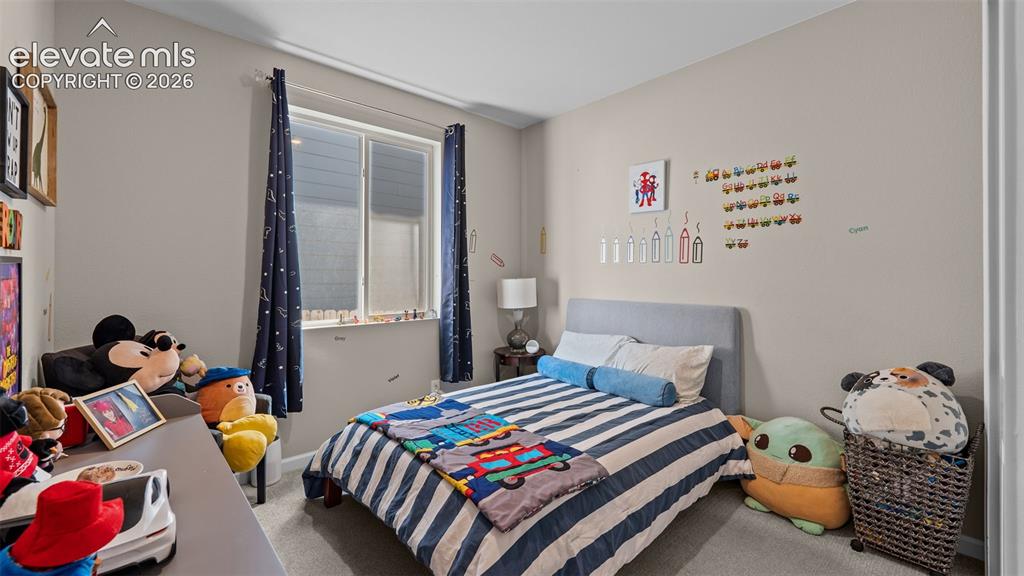 Image 7 of 46: Neutral wall paint, carpeted flooring, and a single window with curtain rod