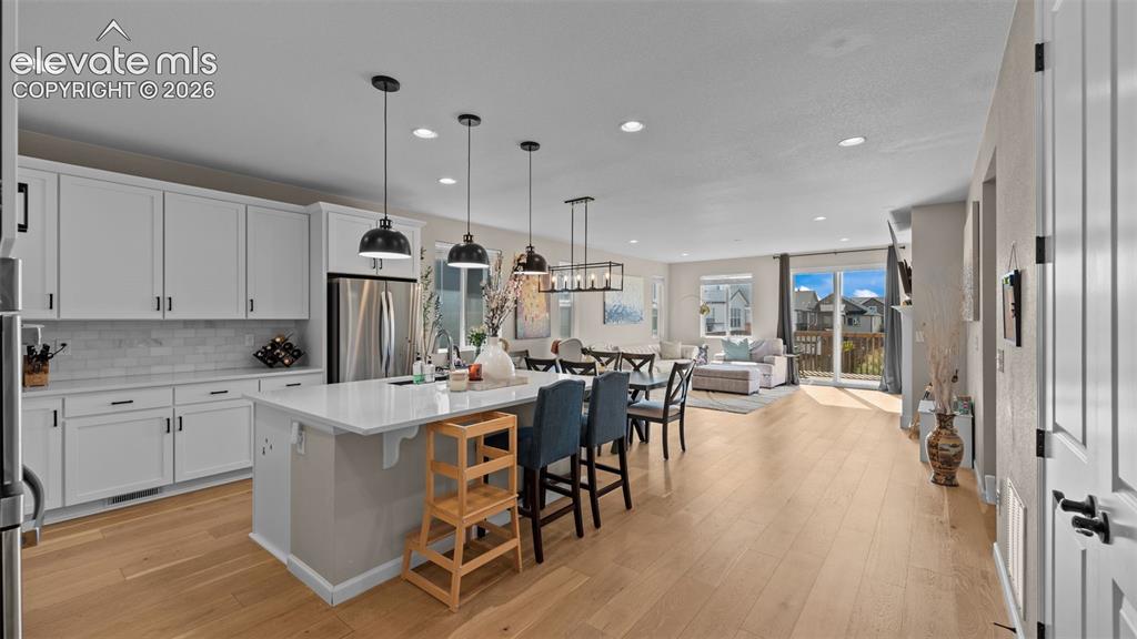 Image 9 of 46: Kitchen featuring white cabinetry, subway tile backsplash, stainless steel