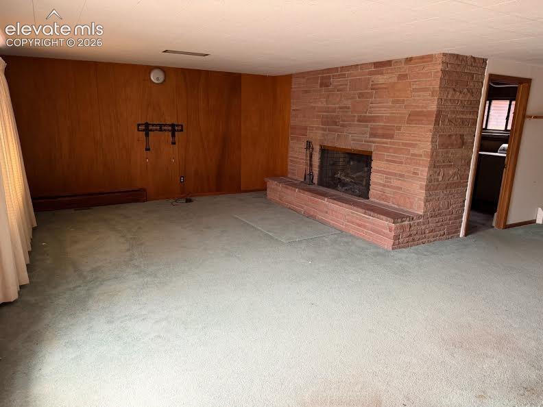 Image 15 of 26: Family room in the basement features a wood burning fireplace.