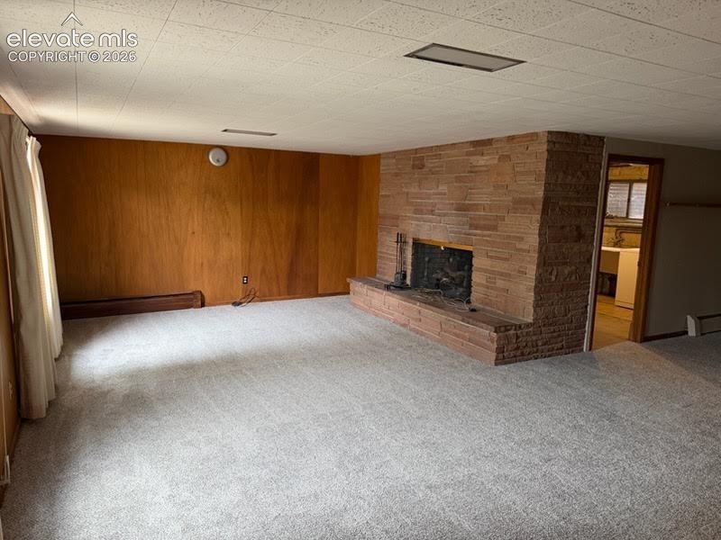 Image 16 of 27: Family room (walk out) in the basement features a wood burning fireplace.