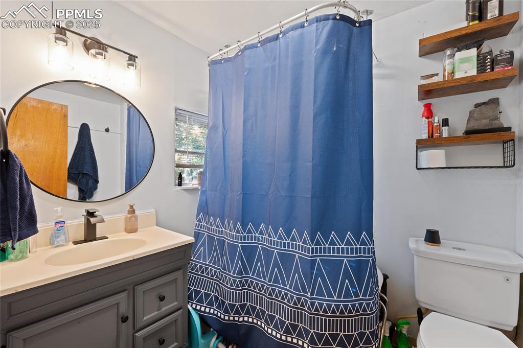 Image 24 of 26: Bathroom with vanity and curtained shower