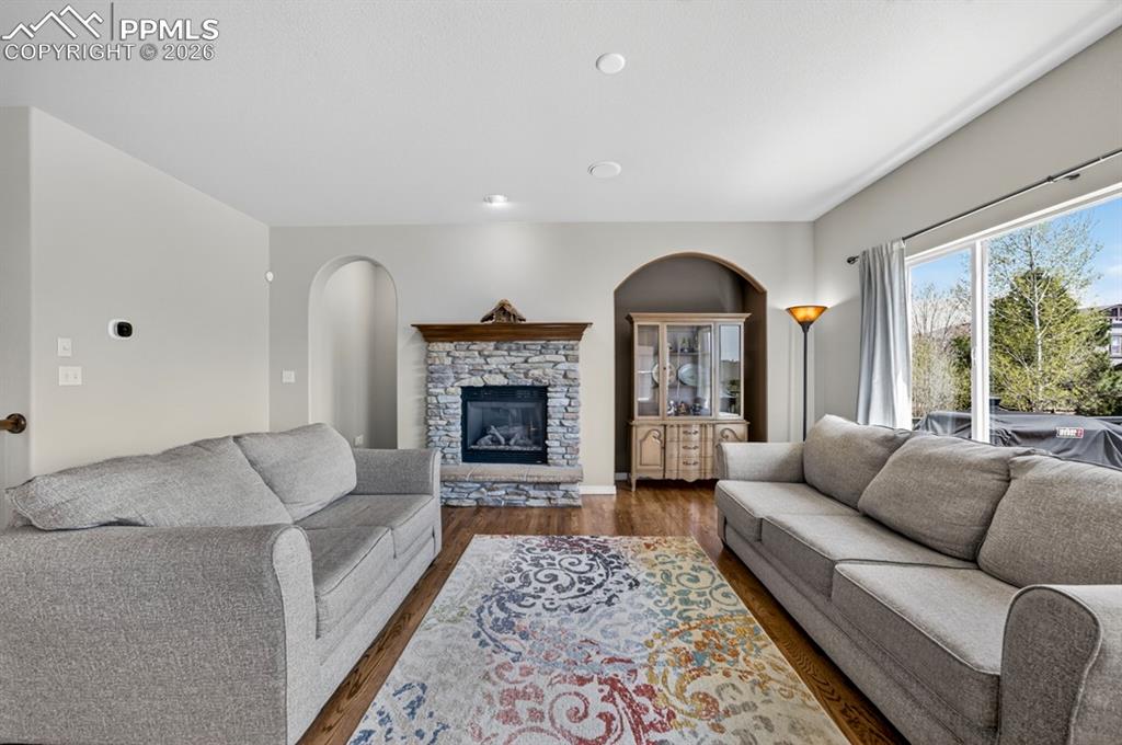 Image 10 of 47: Living area featuring wood-finish flooring and a stone fireplace with a woo