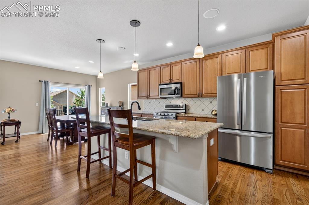 Image 14 of 47: Open-concept kitchen and dining area with wood flooring