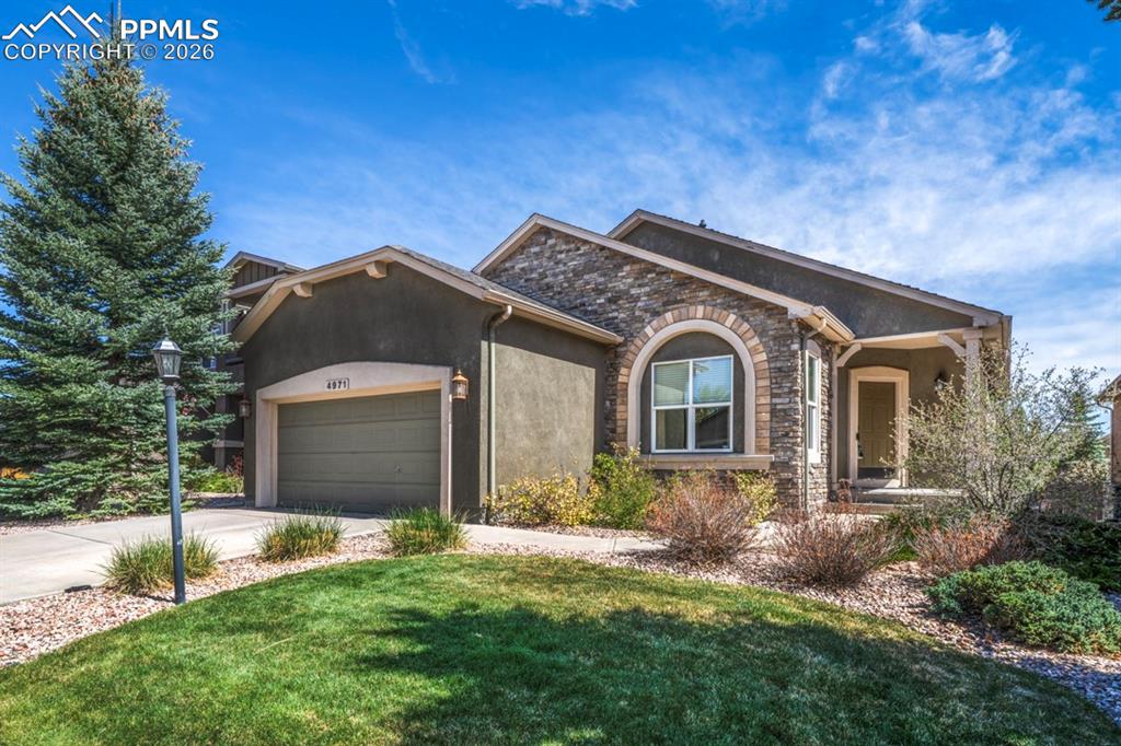 Image 2 of 47: Single-story residence featuring a stone facade and stucco exterior