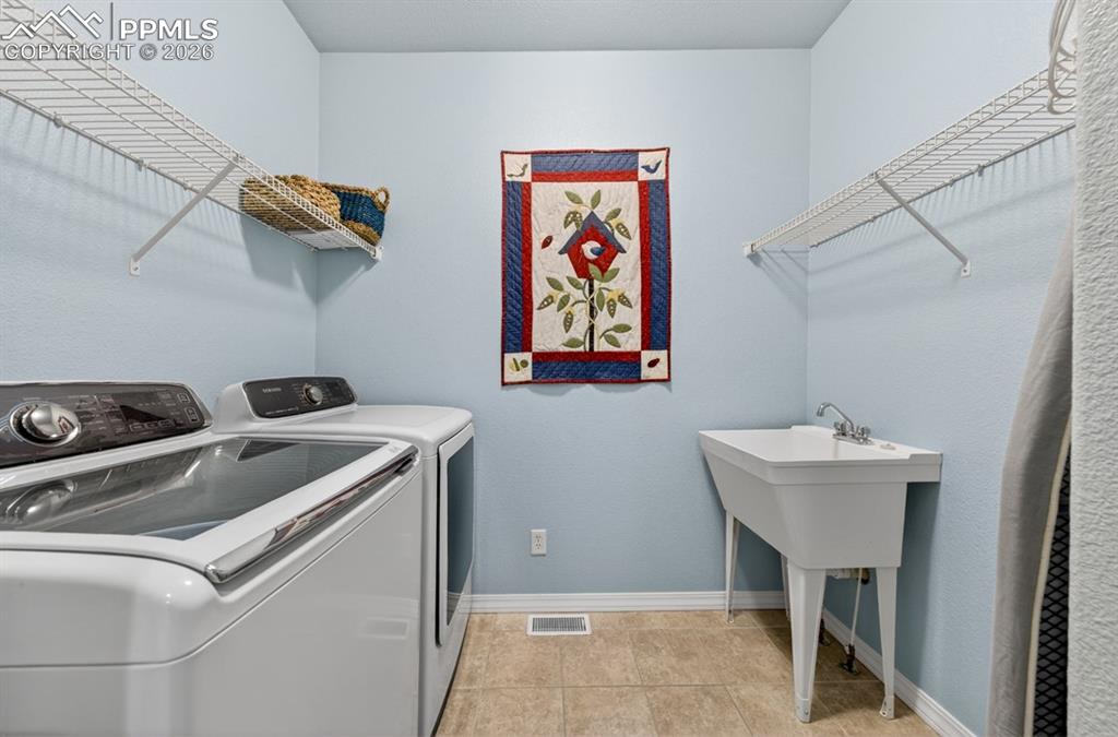 Image 20 of 47: Laundry room with tile flooring and utility sink