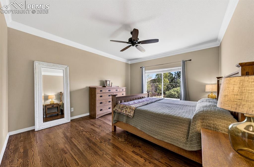 Image 23 of 47: Expansive room featuring rich wood-finish flooring, a ceiling fan, crown mo