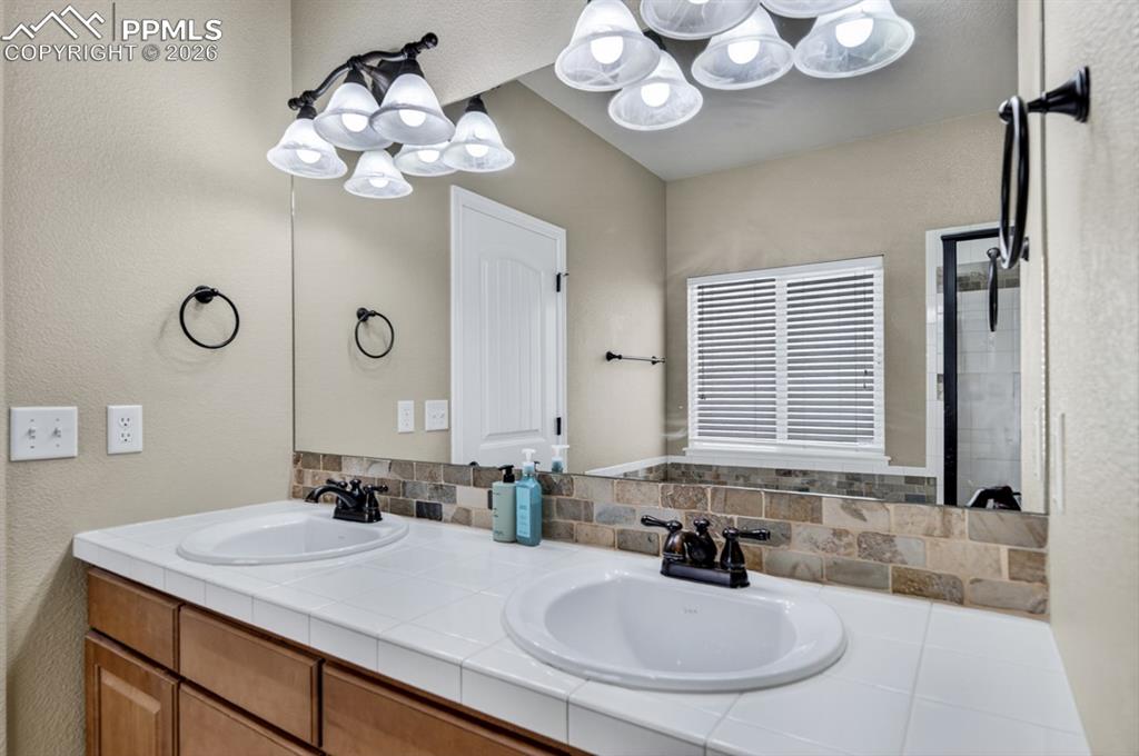 Image 24 of 47: Primary bath with individual oval sinks, and bronze-finish faucets