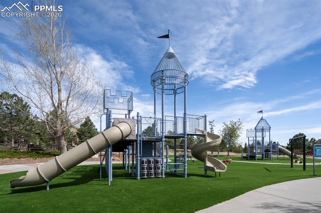 Image 46 of 47: Expansive playground featuring two castle-themed structures, multiple slide
