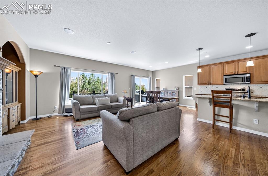 Image 7 of 47: Open-concept living area featuring wood flooring, a kitchen with wood cabin