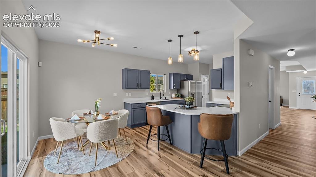 Image 14 of 47: Kitchen and dining area featuring wood-finish flooring, a kitchen island wi
