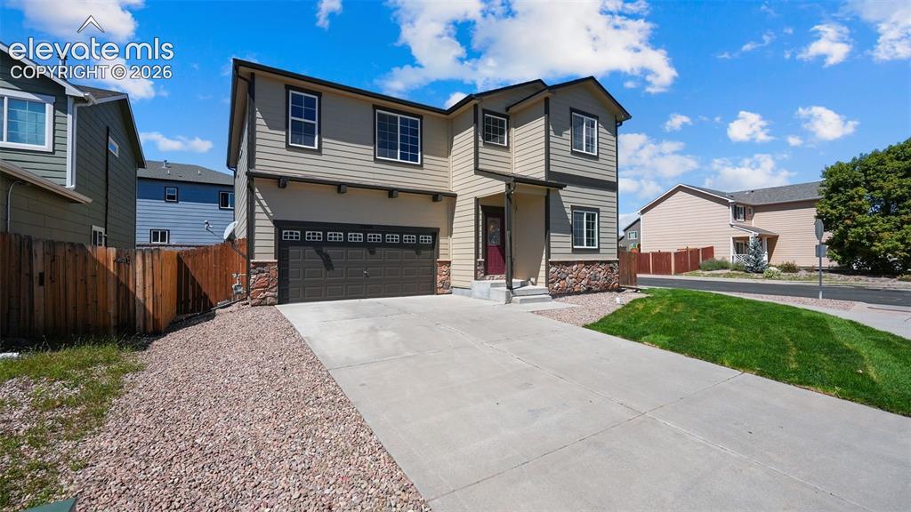 Image 2 of 47: Two-story residence featuring horizontal siding and stone veneer accents