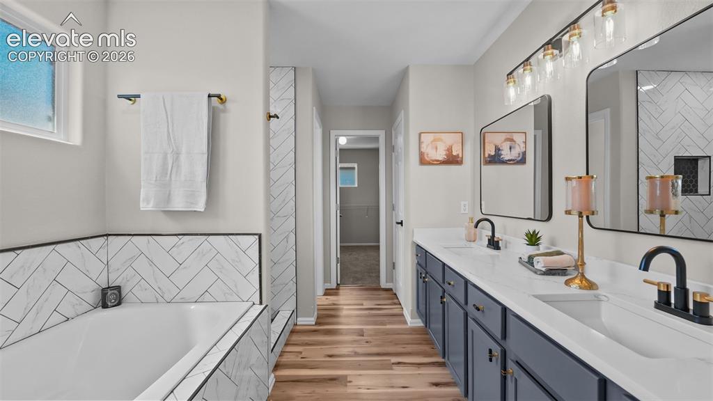 Image 23 of 47: Dual vanity with white countertops, undermount sinks, and dark cabinetry