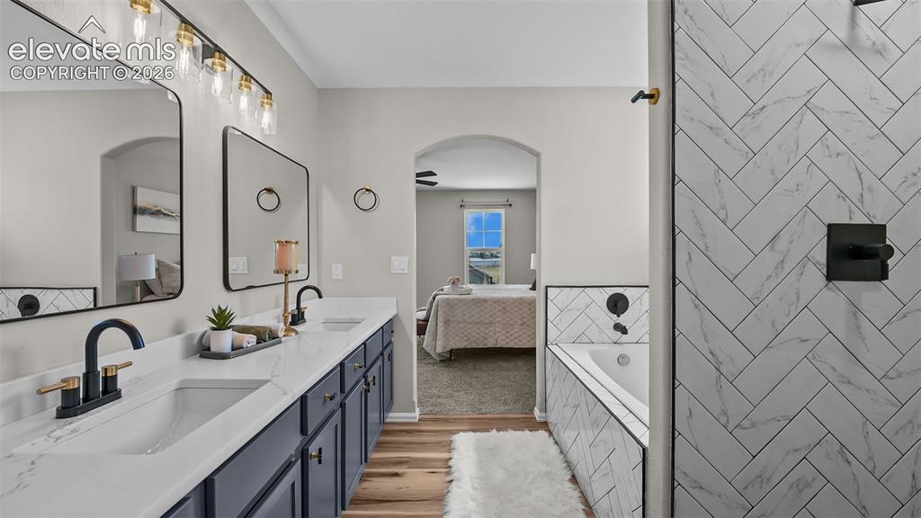 Image 24 of 47: Dual vanity with white countertops, undermount sinks, and matte black fixtu