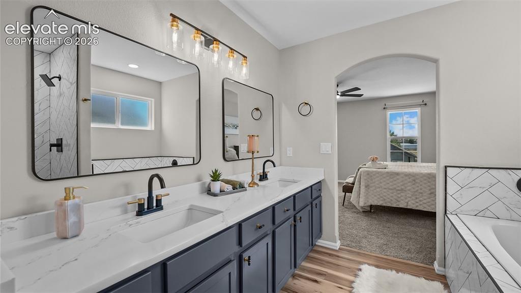 Image 26 of 47: Double vanity with white countertops, dark cabinetry, and matte black fixtu