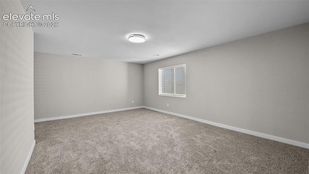 Image 28 of 47: Spacious room featuring neutral carpeting, light-toned walls, and a ceiling